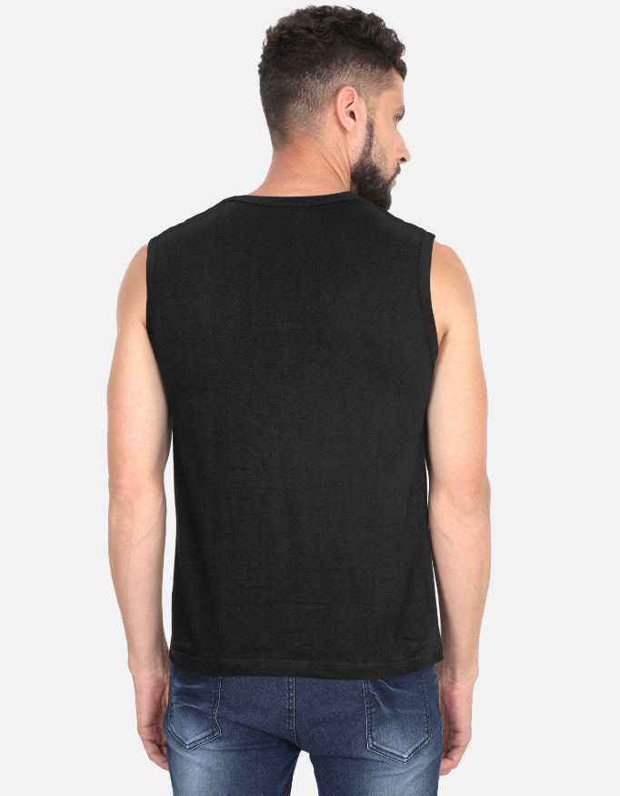 Man wearing a black sleeveless shirt and blue jeans on a white background