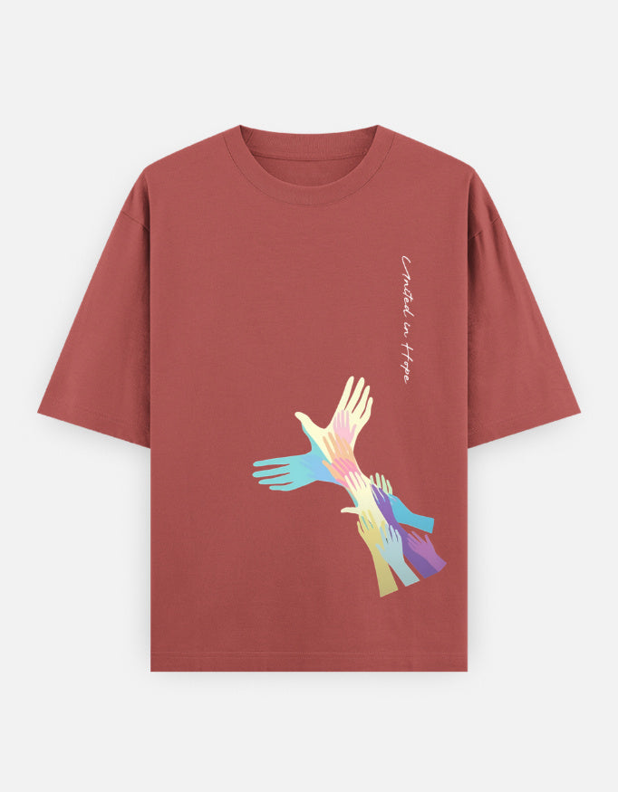 Rust red t-shirt with colorful hands graphic and 'United in Hope' text on front