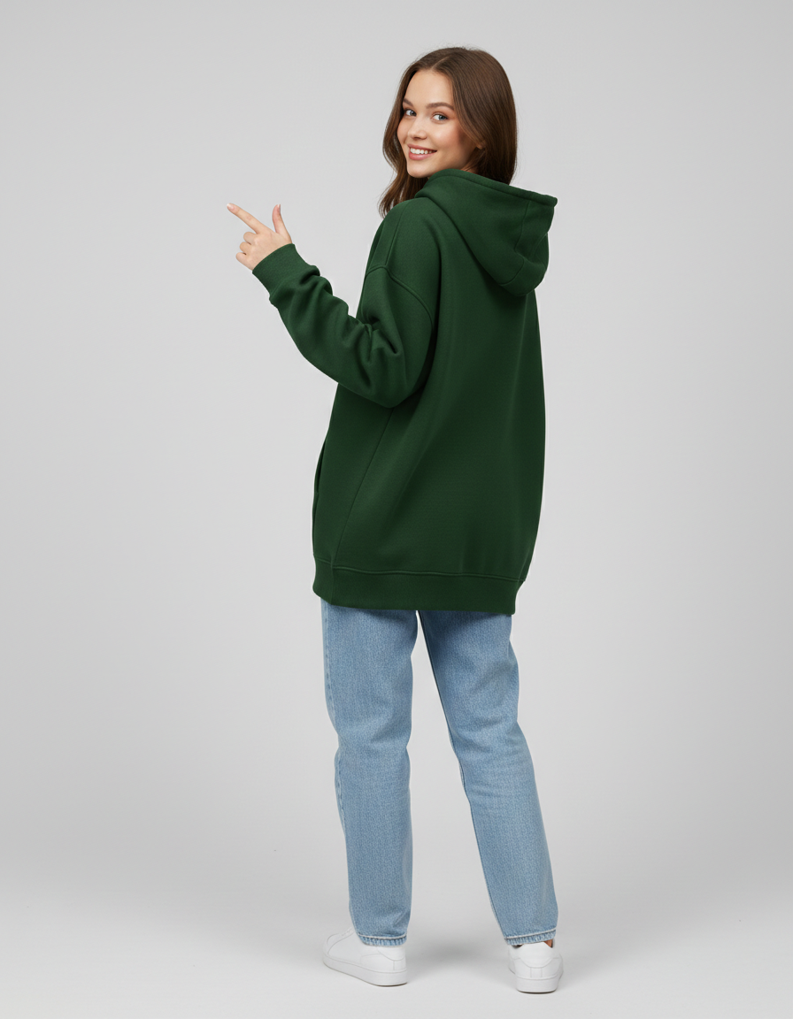 Woman wearing oversized green hoodie, light blue jeans, and white sneakers, posing back view