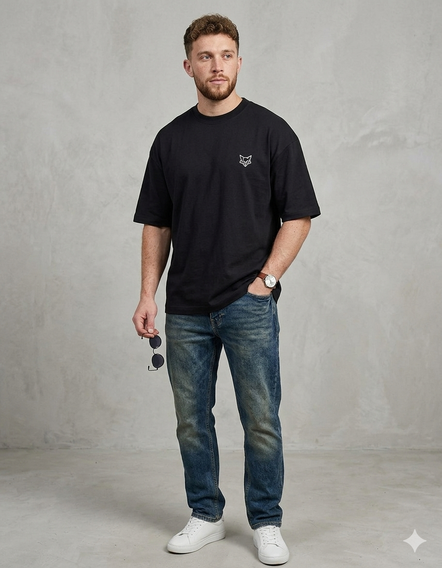 Man in casual black t-shirt with small fox logo, blue jeans, and white sneakers