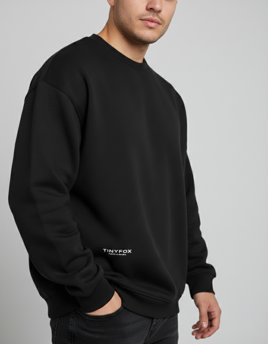 Man wearing oversized black sweatshirt with white Tinyfox logo on front