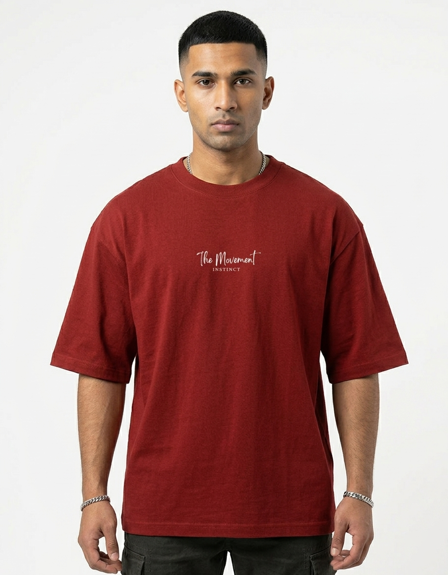 Man wearing a red oversized t-shirt with 'The Movement Instinct' text on the chest
