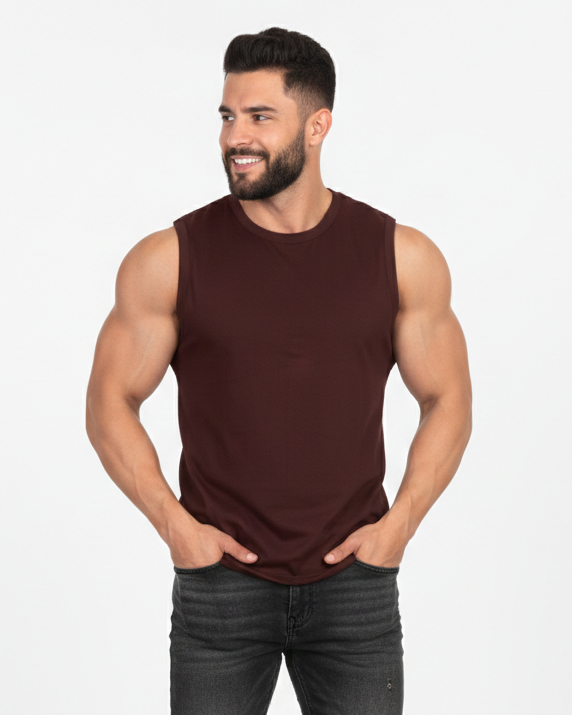 Man wearing a brown sleeveless shirt and black jeans on a white background